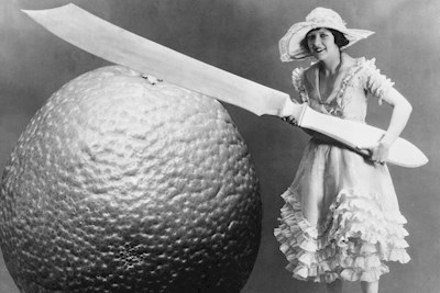 A woman, her giant knife, and a giant orange